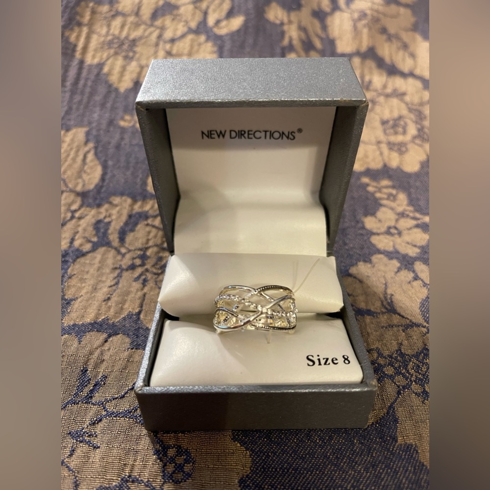 New Directions ring size 8. Silver finish with white stones. New in box.
